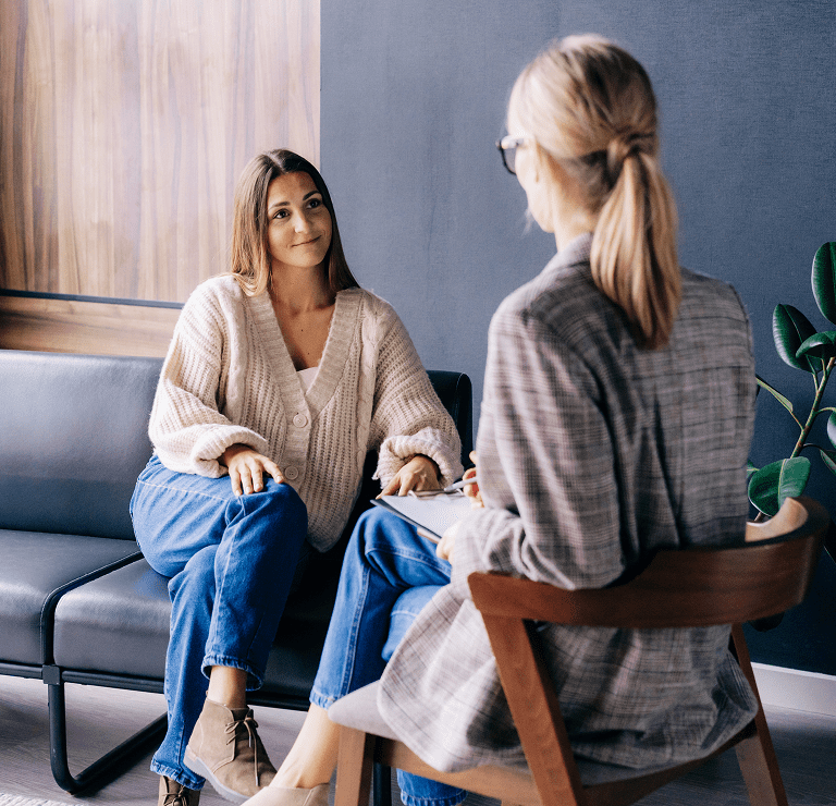 Two women having a conversation on couch.