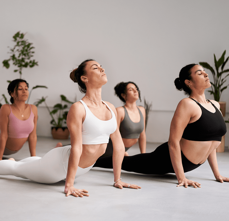 Women practicing yoga in a studio.